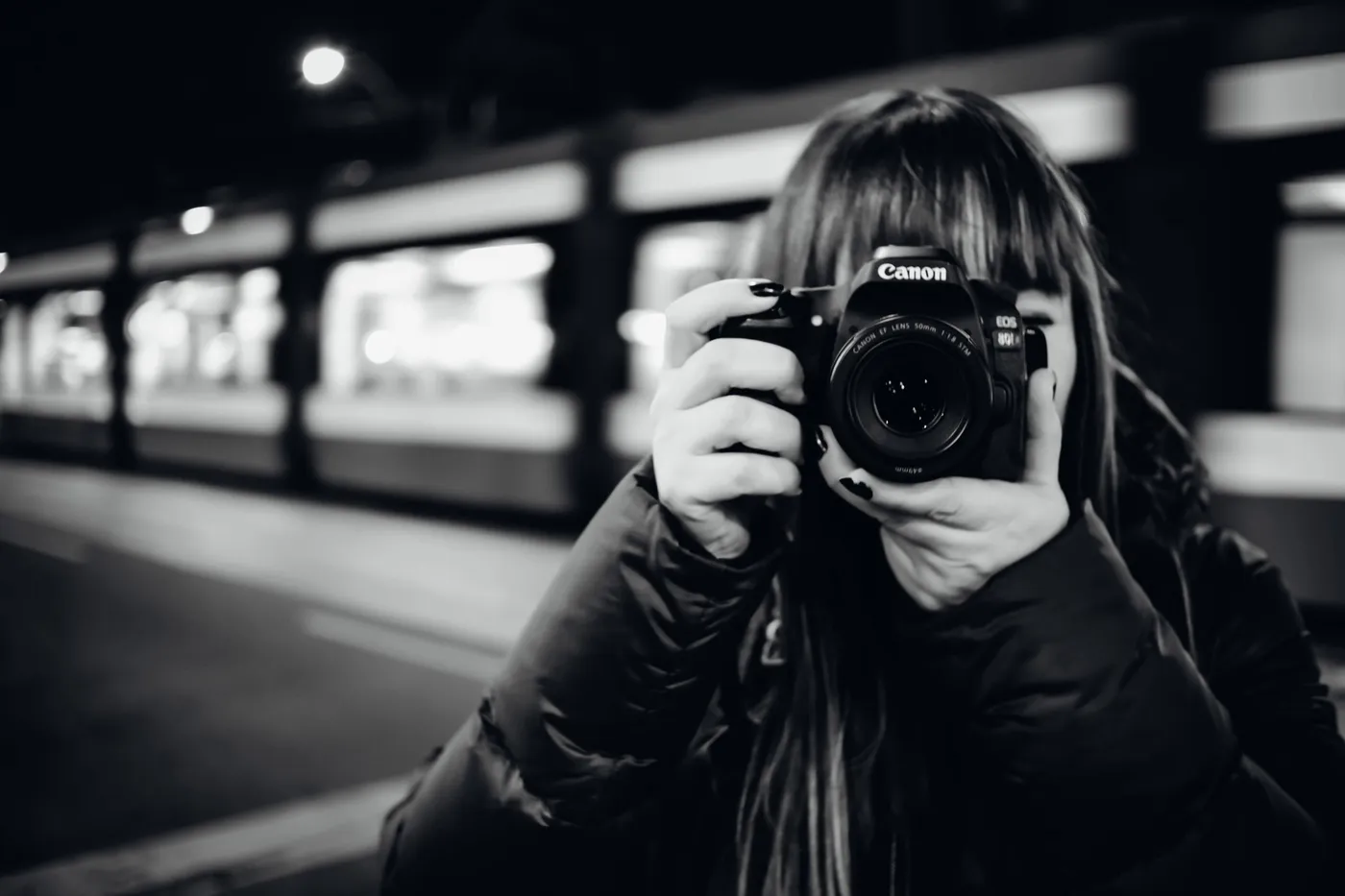 Georgia Sapounas holding a Canon camera in a city at night